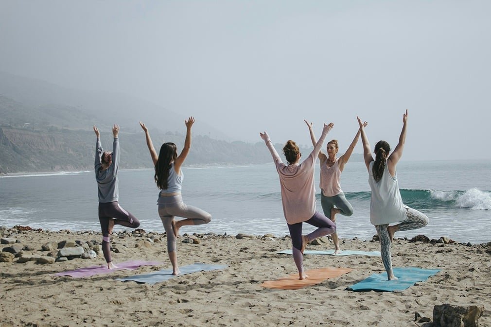 femmes pratiquant du sport sur une plage en complément du drainage lymphatique