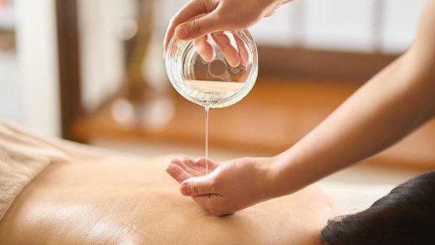 Charlotte Le Bozec avec de l'huile de massage pendant une séance de drainage lymphatique